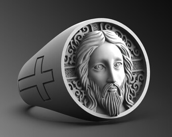May include: A silver ring with a detailed design featuring a face of Jesus Christ and a cross on the side.