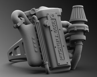 May include: A gray 3D printed model of a car engine with the text "2500 TWIN CAM" on the side.