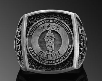 May include: A silver ring with a black and white logo that says "MADD Coffee Independent Distributor" and "maddcoffe.com".