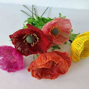K&ouml;nnte beinhalten: Ein Strau&szlig; aus f&uuml;nf Perlen-Mohnblumen in Rot, Rosa, Orange und Gelb. Die Blumen sind aus kleinen Perlen gefertigt und haben ein realistisches Aussehen.