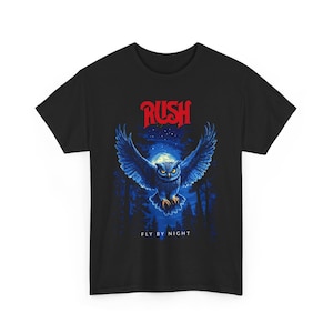 Könnte beinhalten: Schwarzes T-Shirt mit einer blauen Eule, die vor einem Vollmond und einem Wald fliegt. Der Text "RUSH" ist in Rot über der Eule und "FLY BY NIGHT" unter der Eule.