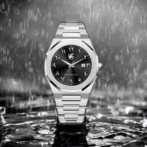K&ouml;nnte beinhalten: Silberne Armbanduhr mit schwarzem Zifferblatt und arabischen Ziffern. Die Uhr hat ein Edelstahlarmband und ein rundes Zifferblatt mit dem Markennamen "R & M Orient". Der Hintergrund zeigt verschwommene Wassertropfen.