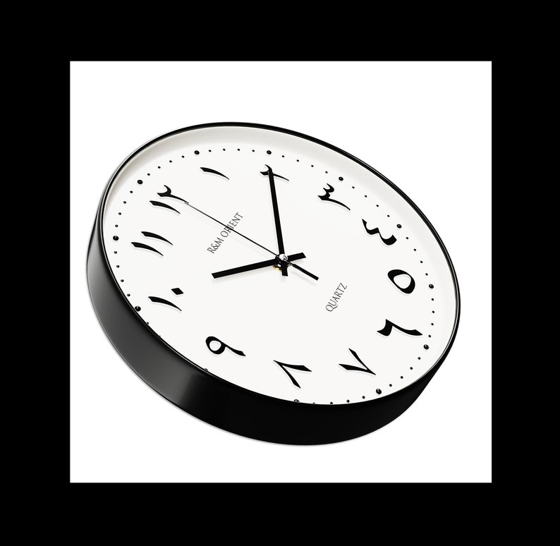 Pu&ograve; includere: Un orologio da parete rotondo bianco e nero con numeri arabi. Il quadrante dell'orologio &egrave; bianco con numeri e lancette neri. L'orologio ha un bordo nero e un'etichetta nera "quartz".