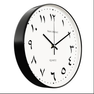 Pu&ograve; includere: Un orologio da parete bianco e nero con numeri arabi. Il quadrante dell'orologio &egrave; bianco con numeri arabi neri e una lancetta dell'orologio nera. L'orologio &egrave; incorniciato in un cerchio nero con un bordo nero.