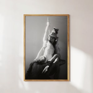 Könnte beinhalten: Schwarzweißfoto einer Skulptur, die zwei Figuren darstellt, eine steht und hält ein Schwert, die andere kniet. Die Skulptur ist aus weißem Marmor und vor einem hellgrauen Hintergrund platziert.