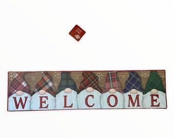 Puede incluir: Una alfombra de bienvenida con una fila de gnomos que llevan sombreros de cuadros y la palabra "WELCOME" en letras rojas.