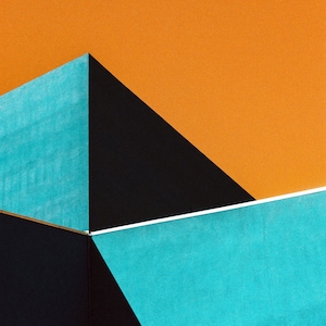 Op de afbeelding: Abstract geometrisch ontwerp met een kleurenschema van zwart, oranje en turquoise. De afbeelding toont drie snijdende vlakken, wat een moderne en minimalistische esthetiek creëert.