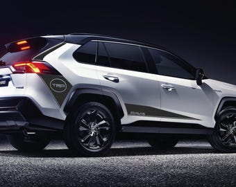 May include: A white Toyota RAV4 with black accents and the words "TRD" and "RAV4" on the side. The car is parked on a dark surface.