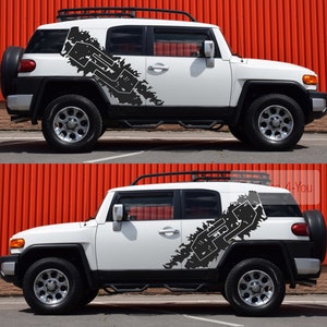 May include: White SUV with a black and white graphic decal on the side. The decal features a stylised letter "F" with a jagged edge design.