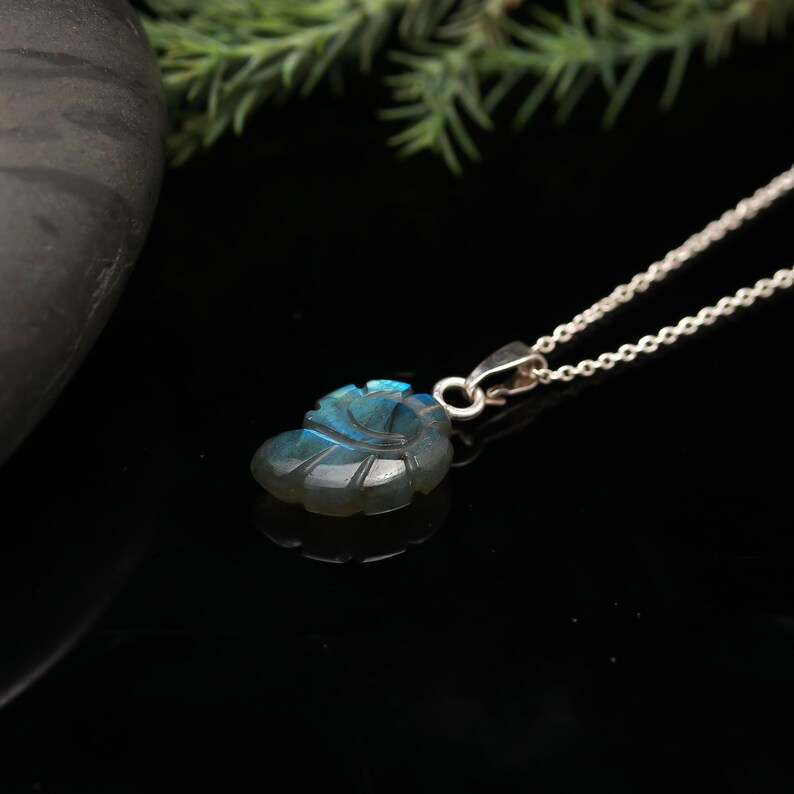 May include: A silver chain necklace with a blue labradorite pendant carved in the shape of a leaf.