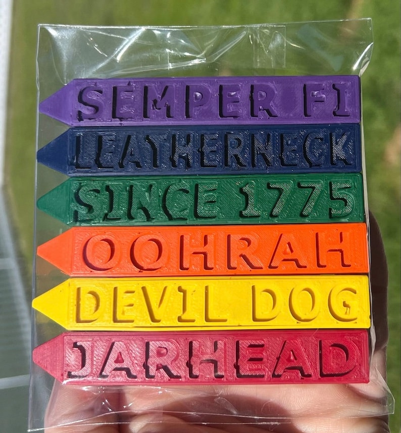 Pu&ograve; includere: Sei pastelli colorati con frasi diverse. Le frasi sono "SEMPER FI", "LEATHERNECK", "SINCE 1775", "OOORAH", "DEVIL DOG" e "JARHEAD".