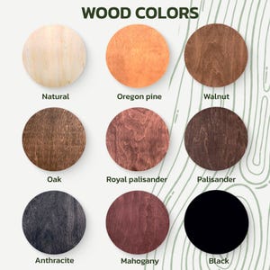 May include: A collection of nine circular wood samples showcasing various wood colors. The samples include Natural, Oregon pine, Walnut, Oak, Royal palisander, Palisander, Anthracite, Mahogany, and Black. The text "WOOD COLORS" is at the top.