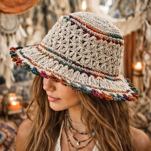 Può includere: Cappello all'uncinetto beige con tesa larga e motivo floreale. Il cappello presenta strisce colorate arancioni, blu, verdi e viola attorno alla corona e alla tesa. Il bordo ha un bordo smerlato.