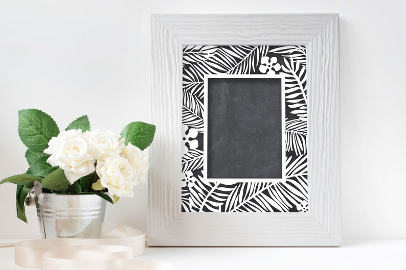 Pu&ograve; includere: Una cornice bianca con un design a foglie tropicali in bianco e nero. La cornice &egrave; vuota e pronta per una foto.