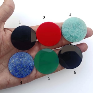 May include: Six round, flat, polished stones in various colours, including black, red, green, blue, and white. The stones are numbered 1 through 6.