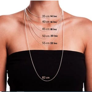 May include: A model wears a silver chain necklace in various lengths, showing the different sizes available. The lengths are labeled in centimeters and inches: 35 cm 14 in, 40 cm 16 in, 45 cm 18 in, 50 cm 20 in, 55 cm 22 in, and 82 cm.