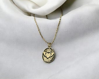 May include: A gold chain necklace with a pendant featuring a crowned heart with wings and floral accents.