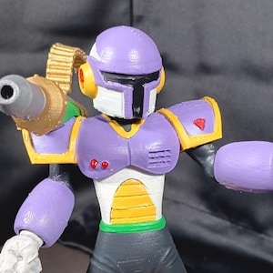 Könnte beinhalten: Detaillierte Figur eines Robotercharakters, hauptsächlich in Lila, Gold und Schwarz. Der Roboter hat einen Helm, Schulterpolster und einen Blaster. Die Figur ist mit ausgestrecktem Blaster posiert und zeigt ihr kompliziertes Design und Farbschema.