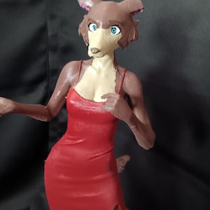 Könnte beinhalten: Eine handbemalte Figur eines anthropomorphen Wolfscharakters mit braunem Fell, heller Schnauze und leuchtend blauen Augen. Die Figur trägt ein leuchtend rotes Kleid mit Spaghettiträgern und Seitenschlitz und steht auf einem runden beigen Sockel.