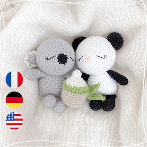 Peut inclure: Deux animaux en peluche crochetés, un koala gris et un panda blanc, sont couchés sur une couverture blanche. Le koala tient un petit biberon crocheté avec un dessus vert.