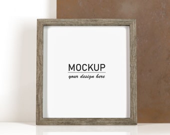 May include: A grey wood picture frame with a white mount and the text "MOCKUP your design here" on a white background.