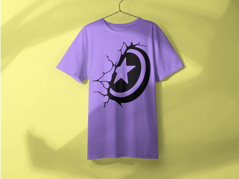 May include: A purple t-shirt with a black graphic of a star inside a circle, appearing to break through the fabric.