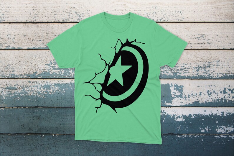 May include: A green t-shirt with a black graphic of a star inside a circle, breaking through a cracked wall.
