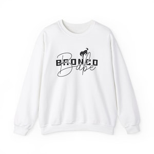 May include: White sweatshirt with a black graphic design that says "Bronco Bape" with a stylized image of a horse.