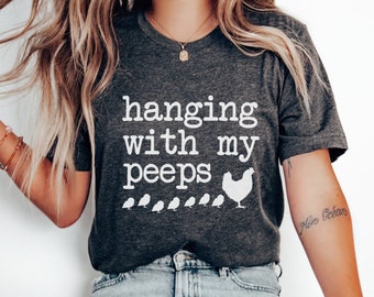 May include: A dark gray heather t-shirt with the text "hanging with my peeps" and a white silhouette of a hen and chicks.