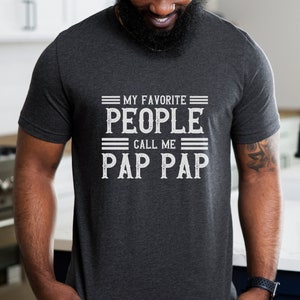 May include: A dark gray t-shirt with the text "My Favorite People Call Me Pap Pap" printed in white.