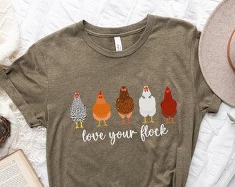 May include: A heather olive t-shirt with a graphic of five chickens in a row and the text "love your flock".
