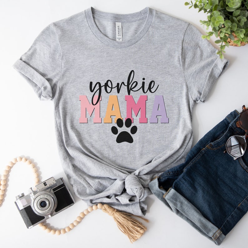 May include: Gray t-shirt with the text "yorkshire mama" in colorful letters and a black paw print.