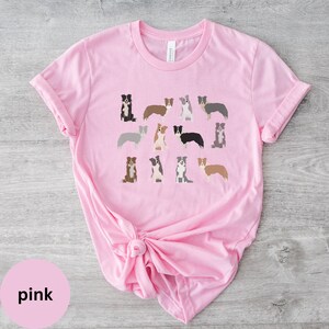 Pode incluir: Camiseta rosa com uma estampa gr&aacute;fica de v&aacute;rios border collies em diferentes poses e cores.