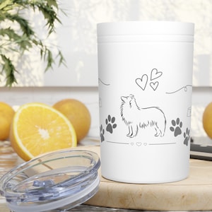 May include: White stainless steel travel mug with a gray outline of a Collie dog, paw prints, and hearts. The mug has a clear lid.