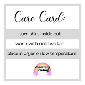 May include: Care card with instructions for washing a shirt: turn shirt inside out, wash with cold water, and place in dryer on low temperature. The card has a rainbow graphic with the text "Cheerfully Printing".