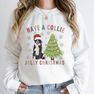 May include: White Christmas sweater with a black and white border collie wearing a Santa hat in front of a green Christmas tree with the text "Have a Collie Jolly Christmas".