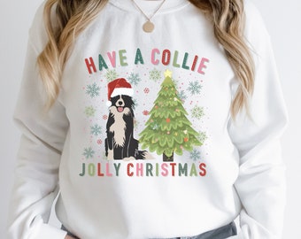 May include: White Christmas sweater with a black and white border collie wearing a Santa hat in front of a green Christmas tree with the text "Have a Collie Jolly Christmas".
