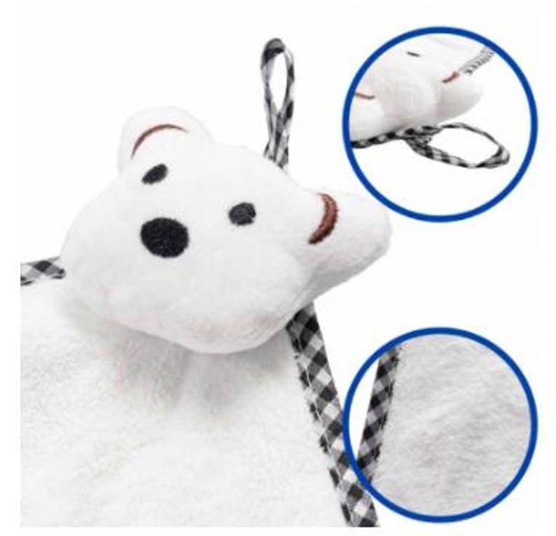 May include: A white plush bear-shaped baby washcloth with black spots for eyes and a nose, and brown embroidered details. It has a black and white checkered loop for hanging. The image includes a close-up of the washcloth's texture and loop.