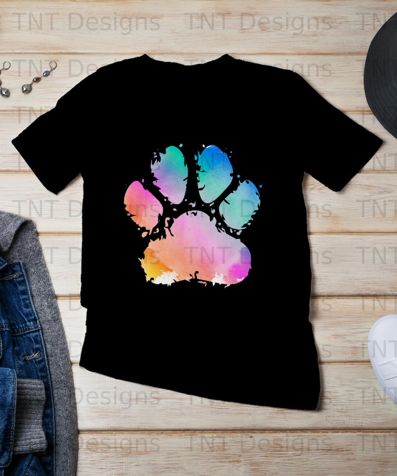 May include: Black t-shirt featuring a colourful watercolour paw print design.