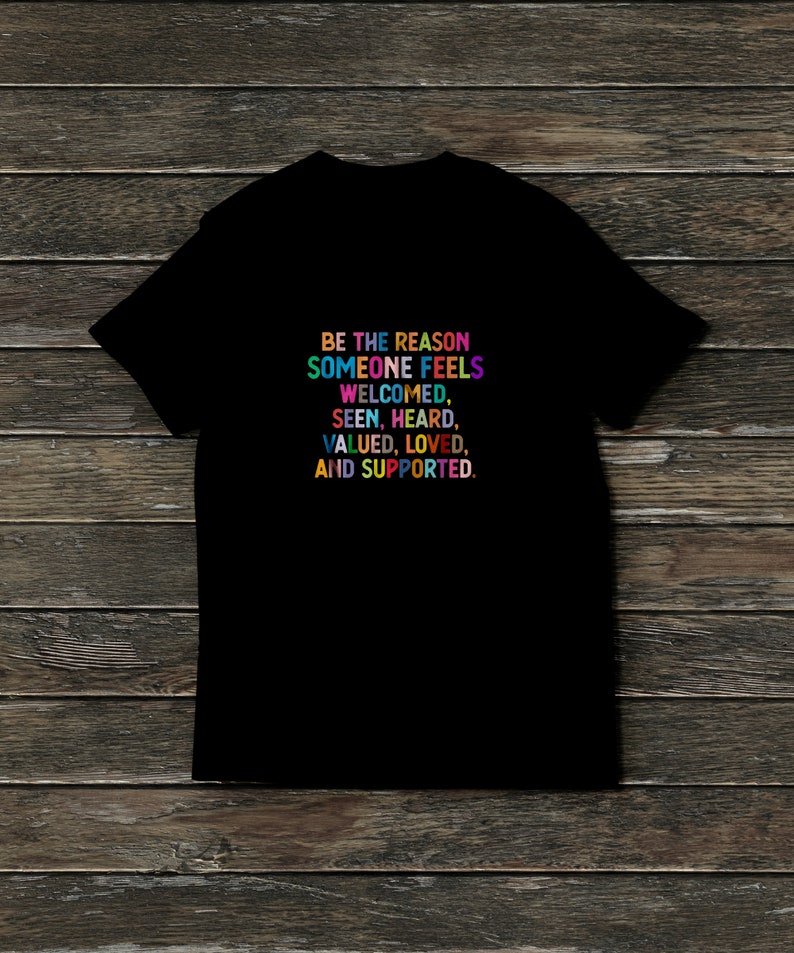K&ouml;nnte beinhalten: Schwarzes T-Shirt mit einer regenbogenfarbenen Botschaft, die lautet: "Sei der Grund, warum sich jemand willkommen, gesehen, geh&ouml;rt, gesch&auml;tzt, geliebt und unterst&uuml;tzt f&uuml;hlt."