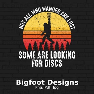 May include: A graphic design featuring a silhouette of Bigfoot holding a disc golf basket above a forest line against a yellow and orange sunset circle. The text reads: NOT ALL WHO WANDER ARE LOST SOME ARE LOOKING FOR DISCS. Below is Bigfoot Designs Png, Pdf, Jpg.