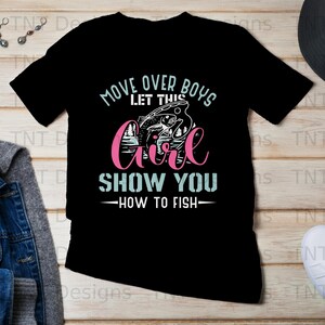 May include: Black t-shirt featuring a graphic design of a girl fishing. The text reads "Move over boys let this girl show you how to fish".