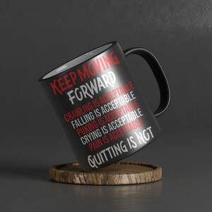 Pode incluir: Caneca de caf&eacute; preta com letras brancas que dizem "KEEP MOVING FORWARD" e uma lista de coisas que s&atilde;o aceit&aacute;veis, incluindo rastejar, cair, vomitar, chorar e dor. A &uacute;ltima linha diz "QUITTING IS NOT".