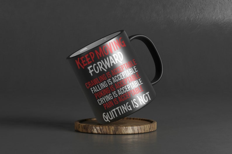 Pode incluir: Caneca de caf&eacute; preta com letras brancas que dizem "KEEP MOVING FORWARD" e uma lista de coisas que s&atilde;o aceit&aacute;veis, incluindo rastejar, cair, vomitar, chorar e dor. A &uacute;ltima linha diz "QUITTING IS NOT".