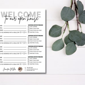 May include: A white open house sign-in sheet with the words "WELCOME to our open house" in gray and black. The form includes fields for name, email, and phone, with checkboxes for real estate timeline options. A sprig of green leaves is in the background.