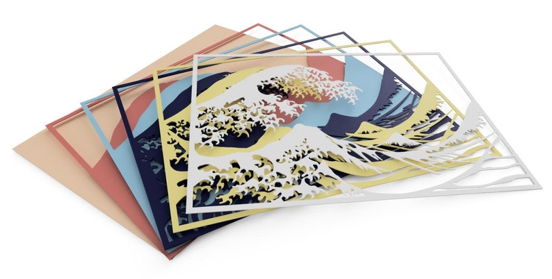 May include: A layered paper art piece depicting the Great Wave off Kanagawa, a famous Japanese woodblock print by Hokusai. The wave is cut out in white paper and layered on top of blue, yellow, pink, and beige paper.