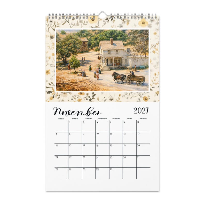 May include: A wall calendar for November 2021 featuring a spiral binding at the top. The upper section displays a painting of a rural 19th-century scene with a wooden house, people, and a horse-drawn wagon, framed by a border of small yellow flowers.