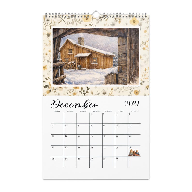 May include: A wall calendar for December 2021 featuring a spiral binding at the top. The upper section displays a watercolor illustration of a wooden cabin in a snowy landscape. The lower section shows a grid with the month name and dates.
