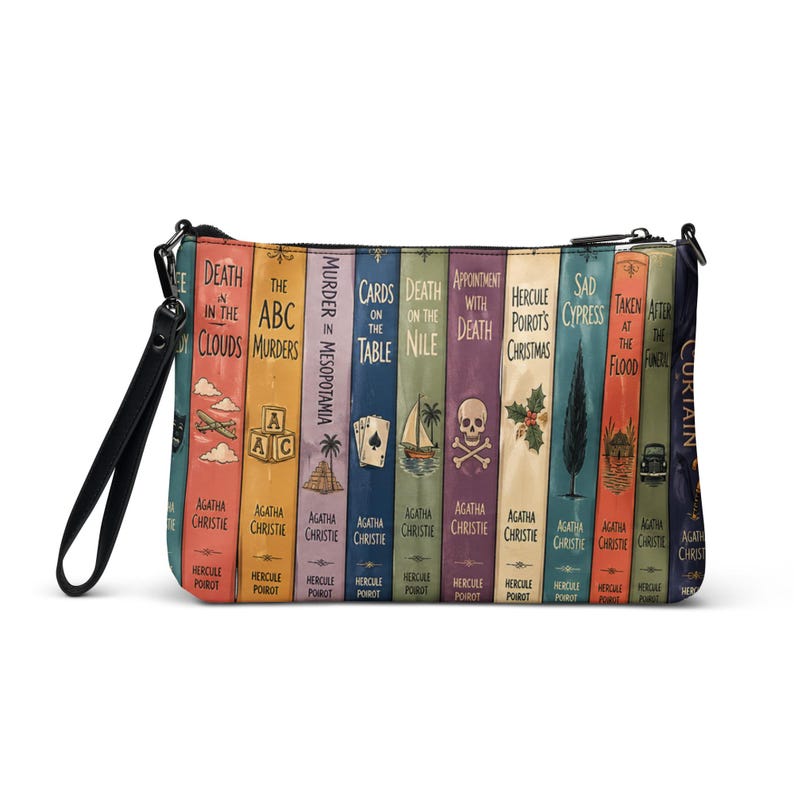 May include: A rectangular zippered wristlet pouch featuring a colourful graphic print of multiple Agatha Christie book spines. The design includes titles like Death in the Clouds, The ABC Murders, and Death on the Nile, with a black wrist strap attached.