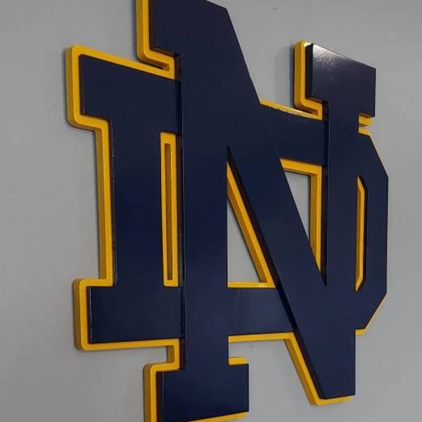 Dale profundidad a tu decoración con nuestro letrero de madera 3D de Notre Dame. Logotipo de Fighting Irish.
